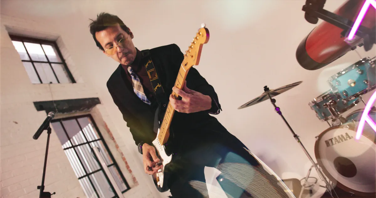 Guitarist with neon and drums