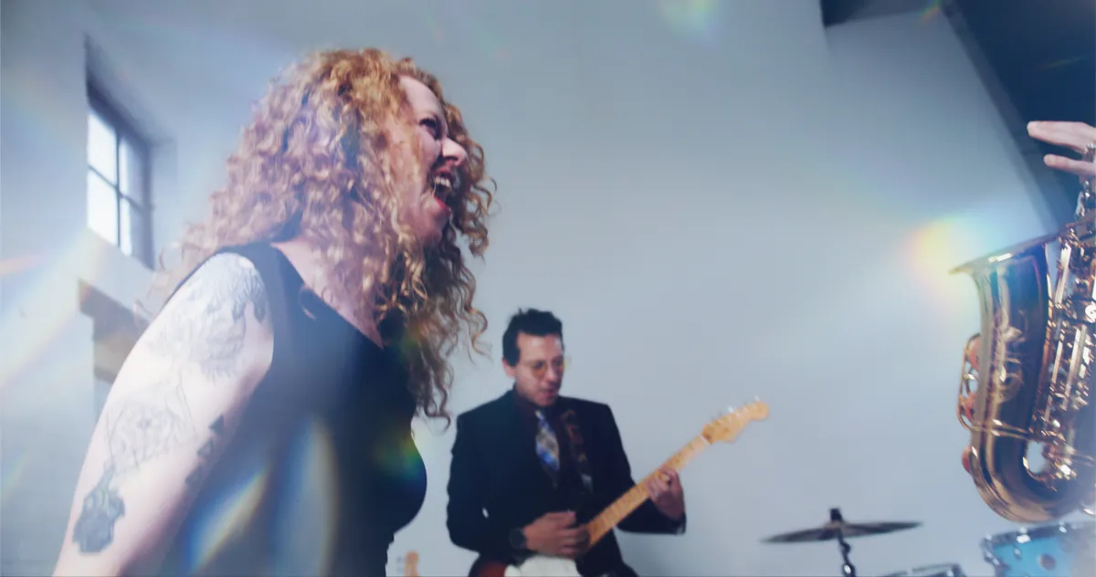 Vocalist and band performing with lens flare